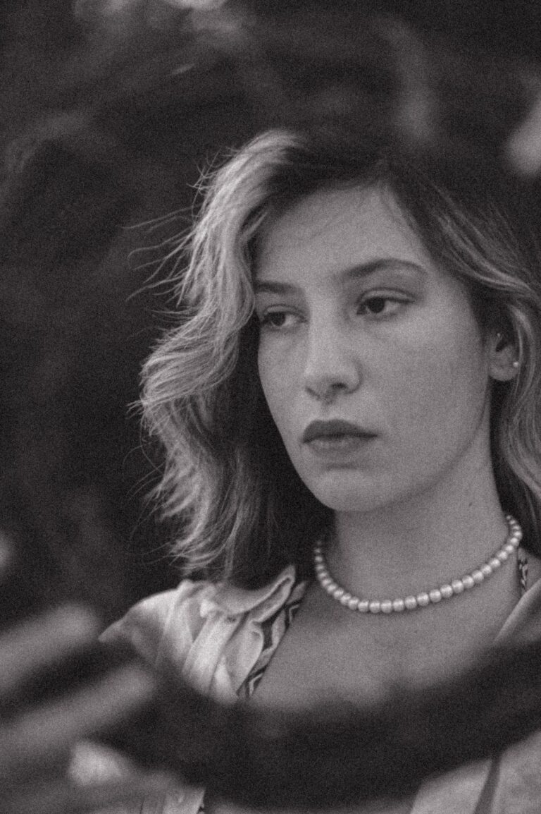 Woman wearing a simple pearl choker, black and white portrait