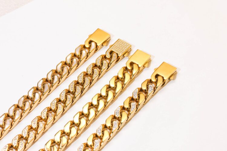 Chunky gold curb chain necklaces on a white surface